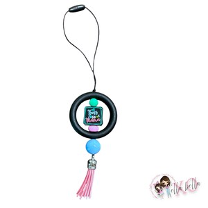 May include: Black car charm with a circular design. The charm features a teal, pink, and black graphic that reads "My Boss Calls Me Mama." It includes a pink tassel, blue and green beads, and a black cord for hanging.
