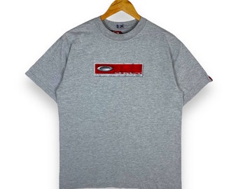 Selten!! Vintage OAKLEY Box Logo Metallplatte Brillen Bekleidung T-Shirt mittlerer Größe