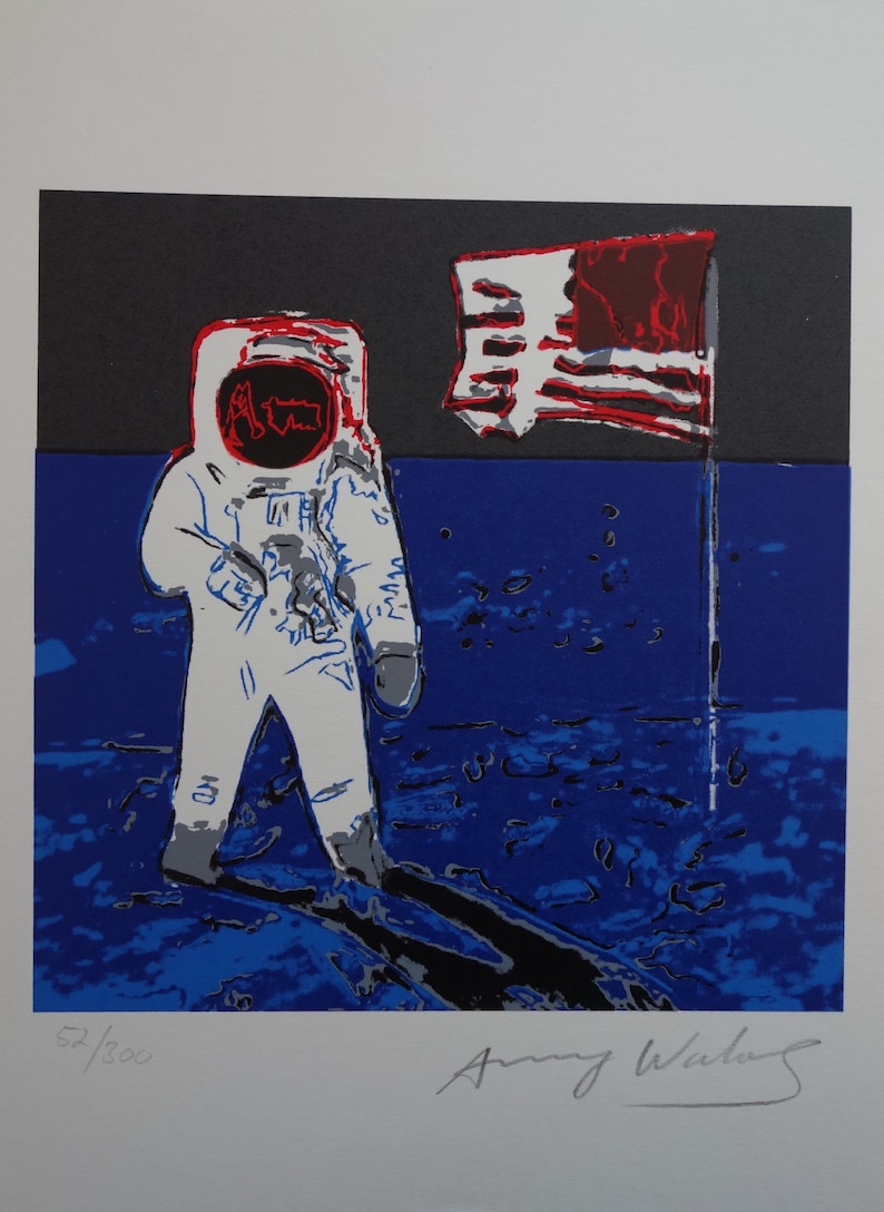 May include: A colorful screen print of an astronaut standing on the moon with an American flag planted in the lunar surface. The astronaut is wearing a white spacesuit with a red helmet. The flag is red, white, and blue. The background is a dark blue with white stars. The print is signed "Andy Warhol" and numbered "52/300".