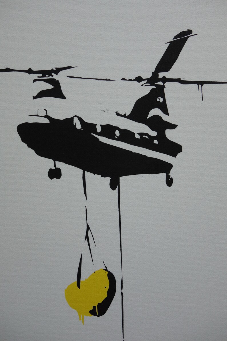 May include: Black and white silhouette of a helicopter carrying a yellow object.