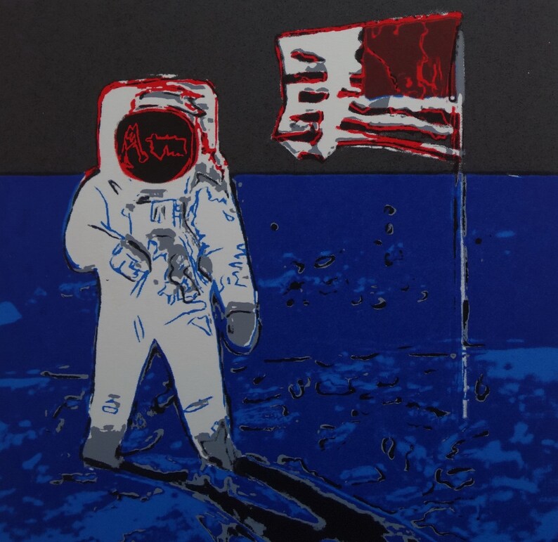 May include: A white astronaut stands on a blue and black surface with a red, white, and blue American flag planted in the ground behind him.