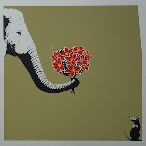 May include: A white elephant with a black trunk holds a bouquet of red flowers. A small black rat stands on the ground looking at the elephant.
