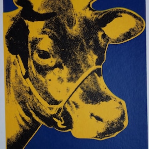 Peut inclure: Gros plan sur la tête d'une vache jaune avec des traits noirs sur un fond bleu. La tête de la vache est tournée sur le côté et son œil est visible. L'image est une impression avec une texture granuleuse.