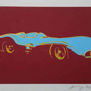 May include: A pop art print featuring a light blue race car with yellow accents against a deep red background. The artwork is signed and numbered, showcasing a bold, graphic style.