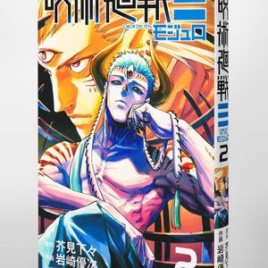May include: A manga volume with a striking illustration of a character with blue hair, horns, and a third eye. The cover features Japanese text and the number "2". The background has a golden hue, and the overall style is anime-inspired.