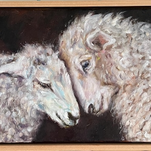 May include: An oil painting depicting two sheep with white, textured wool, their heads close together. The artwork is set against a dark backdrop and is presented in a wooden frame.