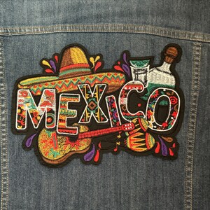 Puede incluir: Parche bordado con la palabra "MEXICO" en letras de colores, rodeado de un sombrero, una guitarra, maracas y una botella de tequila.