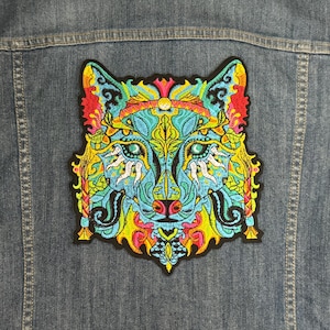 May include: A colorful embroidered patch of a wolf's face with intricate details in shades of blue, green, yellow, and pink.