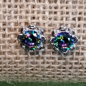 May include: A pair of silver earrings with a round, iridescent gemstone set in a flower-shaped design.