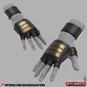 Könnte beinhalten: Ein Paar schwarze fingerlose Handschuhe mit goldenen Akzenten. Die Handschuhe haben ein Handgelenkband und ein strukturiertes Design.