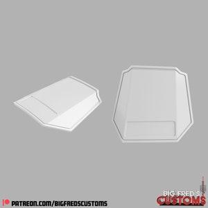 Puede incluir: Dos piezas de plástico blanco, posiblemente para un disfraz o un accesorio. Las piezas tienen forma de escudos con un borde elevado alrededor del perímetro.