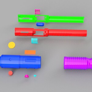 May include: Assortment of colorful plastic pieces for building a toy lightsaber. The pieces include a green, red, blue, and purple tube, a yellow circle, and several small rectangular pieces in various colors.