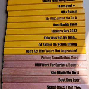 Puede incluir: Un conjunto de 14 l&aacute;pices de madera amarillos y marrones con varios refranes humor&iacute;sticos grabados en ellos. Los refranes incluyen "Oh Sugar!" "Stolen From Greg Nutter" "I Love You!" "Oji's Pencil" "My Wife Made Me Do It" "Best Daddy Ever!" "Father's Day 2022" "This Was Not My Idea..." "I'd Rather Be Scuba Diving" "Don't Act Like You're Not Impressed" "Father, Grandfather, Hero" "Will Work For Sprite & Donuts" "She Made Me Do It" "Best Day Ever" "Stand Back, I Got This".