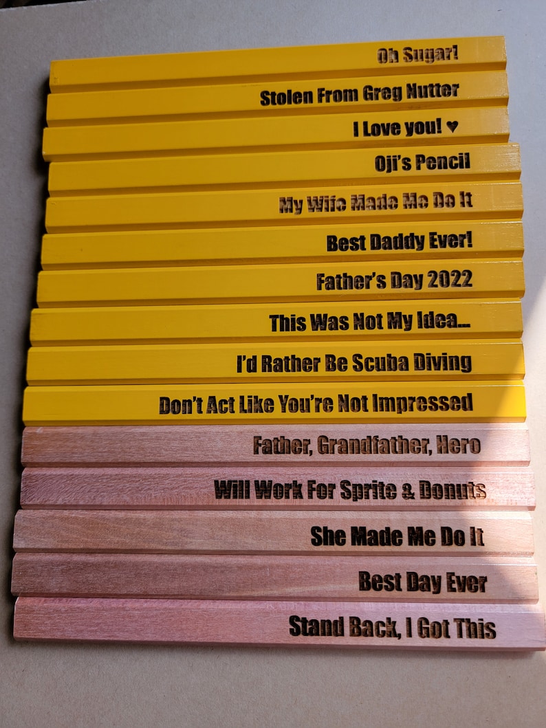 Puede incluir: Un conjunto de 14 l&aacute;pices de madera amarillos y marrones con varios refranes humor&iacute;sticos grabados en ellos. Los refranes incluyen "Oh Sugar!" "Stolen From Greg Nutter" "I Love You!" "Oji's Pencil" "My Wife Made Me Do It" "Best Daddy Ever!" "Father's Day 2022" "This Was Not My Idea..." "I'd Rather Be Scuba Diving" "Don't Act Like You're Not Impressed" "Father, Grandfather, Hero" "Will Work For Sprite & Donuts" "She Made Me Do It" "Best Day Ever" "Stand Back, I Got This".