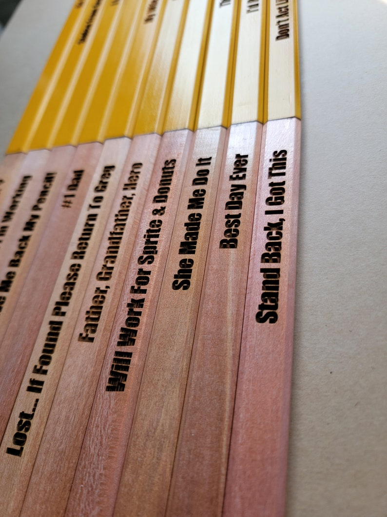 Puede incluir: Un conjunto de diez l&aacute;pices de madera con diferentes lemas grabados. Los l&aacute;pices est&aacute;n pintados de amarillo en la mitad superior y de madera natural en la mitad inferior. Los lemas incluyen "Lost... If Found Please Return To Greg", "Father, Grandfather, Hero", "Will Work For Sprite & Donuts", "She Made Me Do It", "Best Day Ever", "Stand Back, I Got This", "Don't Act Like You're Not Working", "Me Back My Pencil!", "#1 Bad", y "T".