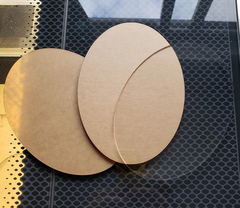 May include: Two round, brown, wooden discs and a clear, round, glass disc. The wooden discs are slightly larger than the glass disc.