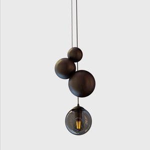 May include: A modern black pendant light fixture with three round, orb-shaped shades and a clear glass globe with a light bulb.