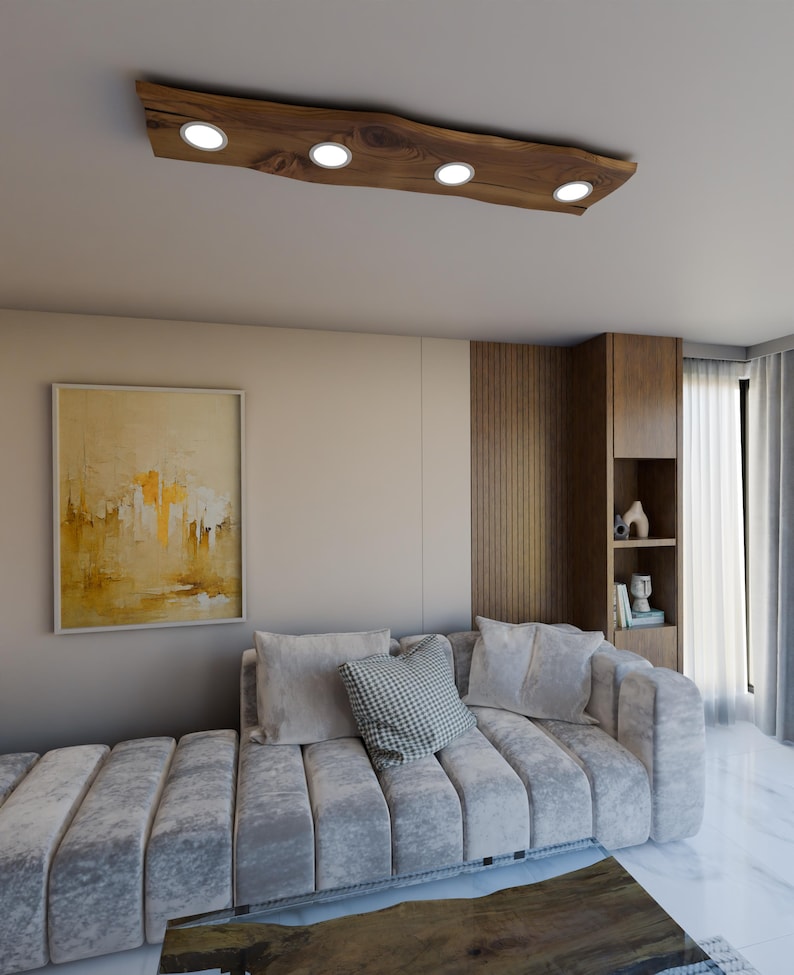 May include: A modern living room featuring a grey sectional sofa, a wooden coffee table, and a distinctive wooden ceiling light fixture with four round light bulbs.