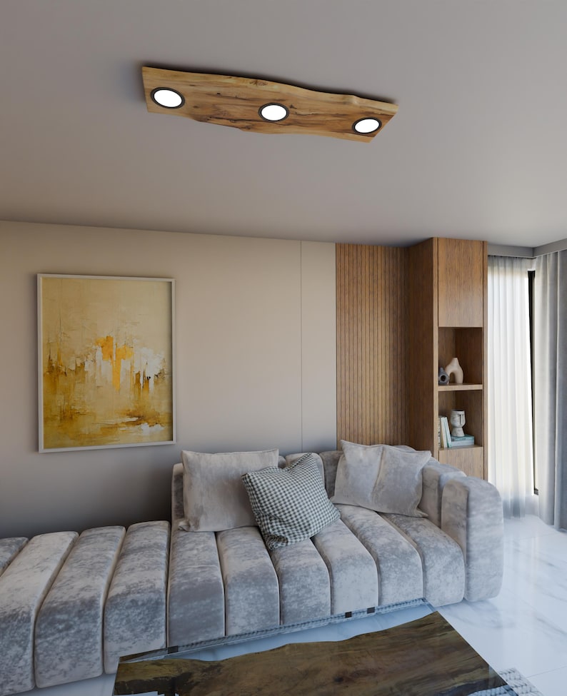May include: A modern living room featuring a grey sectional sofa and a wooden ceiling light fixture with four round lights. The light fixture is crafted from natural wood with a rustic finish.