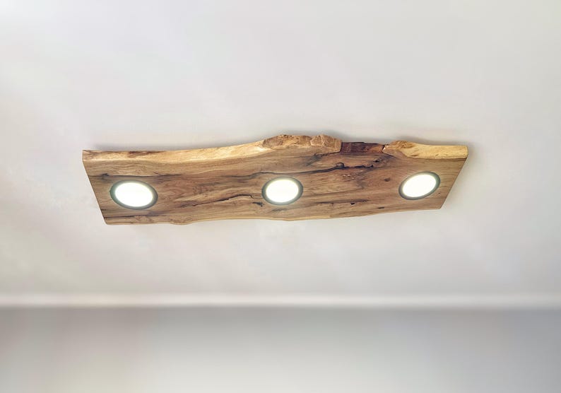 May include: A wooden ceiling light fixture with a natural wood finish and three round light bulbs.