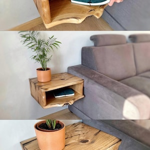 May include: A wooden wall-mounted shelf with a curved edge and a lower shelf. The shelf is made of natural wood with a rustic finish and is shown with a potted plant and a book on the shelf.
