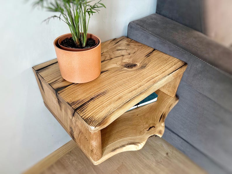 May include: A rustic wooden wall-mounted shelf with a natural wood finish and a small shelf underneath. A potted plant sits on the top shelf.