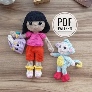 May include: Crochet pattern PDF for a girl doll with black hair, a pink shirt, orange pants, and a purple purse, and a blue monkey with yellow accents and red boots.