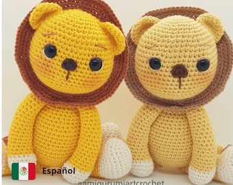 Puede incluir: Dos peluches de león tejidos a crochet, uno amarillo y otro marrón claro, sentados uno al lado del otro. Ambos tienen melenas marrones y pies blancos. Los peluches tienen ojos negros y narices marrones. El texto "@amigurumiartcrochet" es visible debajo de los peluches.