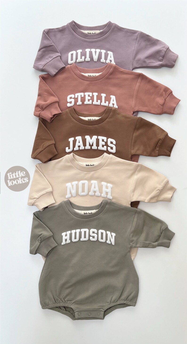 May include: Five long-sleeved baby onesies in different colors with white embroidered names: Olivia, Stella, James, Noah, and Hudson.