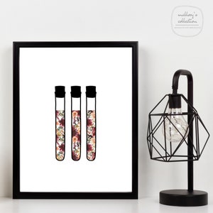 May include: Three clear glass test tubes filled with a floral pattern in shades of pink, red, and white. The test tubes have black tops.