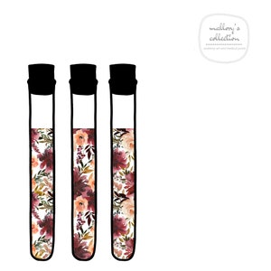 May include: Three clear glass test tubes with black tops filled with a floral pattern in shades of pink, red, and white.