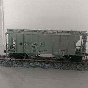 May include: A gray model train car with the words "Rutland 508" printed on the side. The car has a hopper design and is made of metal.