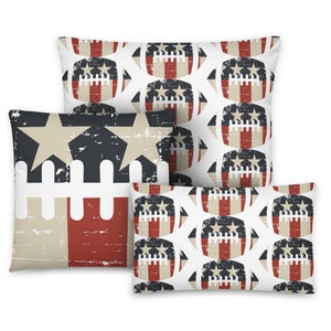 May include: Four decorative throw pillows with patriotic designs. One pillow features a distressed American flag design with stars and stripes. The other three pillows have a repeating pattern of footballs with stars and stripes in red, white, and blue.