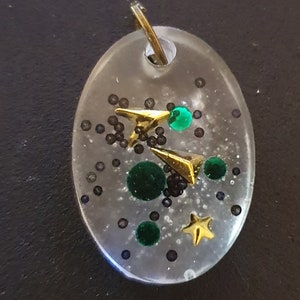 Ovaler Klarer Harz Anhänger mit Goldstern und Pfeilen mit grünen Edelsteinen und schwarzen Kaviarperlen