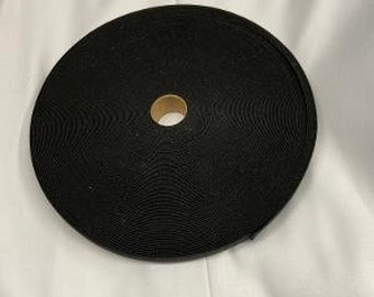 May include: A black, rolled up, fabric strap with a brown center hole.