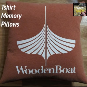 May include: A rust-colored pillow with a white graphic of a boat and the text "WoodenBoat". The pillow is made of a soft, comfortable fabric and is perfect for adding a touch of nautical style to any room.