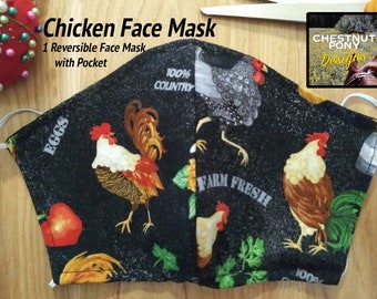 May include: A black reversible face mask with a chicken and egg print. One side features a rooster with the text "EGGS" and "100% COUNTRY". The other side features a rooster with the text "FARM FRESH" and "100%". The mask has a pocket for a filter.