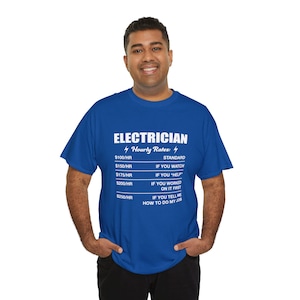 May include: A blue t-shirt with the word "ELECTRICIAN" in white block letters. Below the word are the words "Hourly Rates" and a list of hourly rates and conditions. The shirt is being worn by a person.