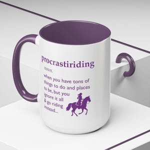 Puede incluir: Taza de cerámica blanca con interior y asa morados. La taza presenta la palabra "procrastiriding" y una definición, junto con un gráfico de una persona montando a caballo, todo en morado.