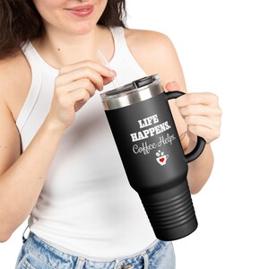 Peut inclure: Mug de voyage en acier inoxydable noir avec une poignée noire. Le mug porte une inscription blanche qui dit "Life Happens. Coffee Helps." avec un petit cœur rouge dans un graphique de tasse à café.