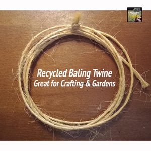 May include: A close-up of a natural-colored twine, coiled in a circle on a wooden surface. The twine is labeled "Recycled Baling Twine Great for Crafting & Gardens".