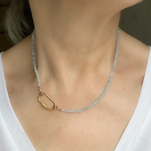 May include: A delicate necklace with a gold clasp and light blue beads.