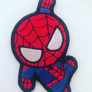 May include: An iron-on patch featuring a cartoon Spider-Man, embroidered in red and blue with a white face and black outline.