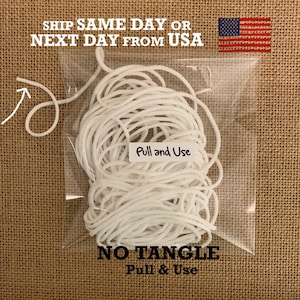May include: A clear plastic bag filled with white elastic cord. The bag has a label that says "Pull and Use". The text "NO TANGLE Pull & Use" is printed below the bag.