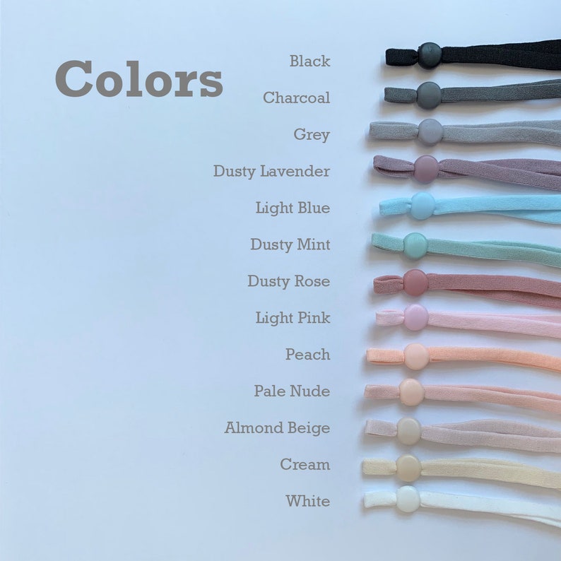 May include: A range of colours of elastic cord with a button on the end. The colours are black, charcoal, grey, dusty lavender, light blue, dusty mint, dusty rose, light pink, peach, pale nude, almond beige, cream, and white.