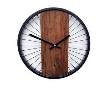A rustic wall clock made of old wood combined with spokes and a bicycle wheel, a unique gift