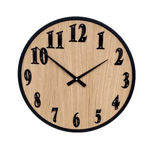 May include: Round wall clock with a light wood grain face and black numerals and hands. The clock has a black rim and is set against a white background. The clock hands point to 10:50.