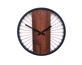 A rustic wall clock made of old wood combined with spokes and a bicycle wheel, a unique gift