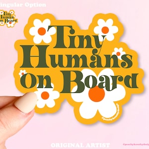 May include: Yellow sticker with the text "Tiny Humans on Board" in green letters. The sticker is decorated with white daisies with orange centers.
