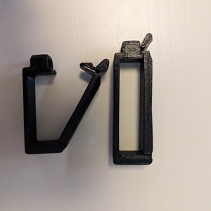 May include: Two black plastic cable clips, one with a hinged design and the other with a straight design.